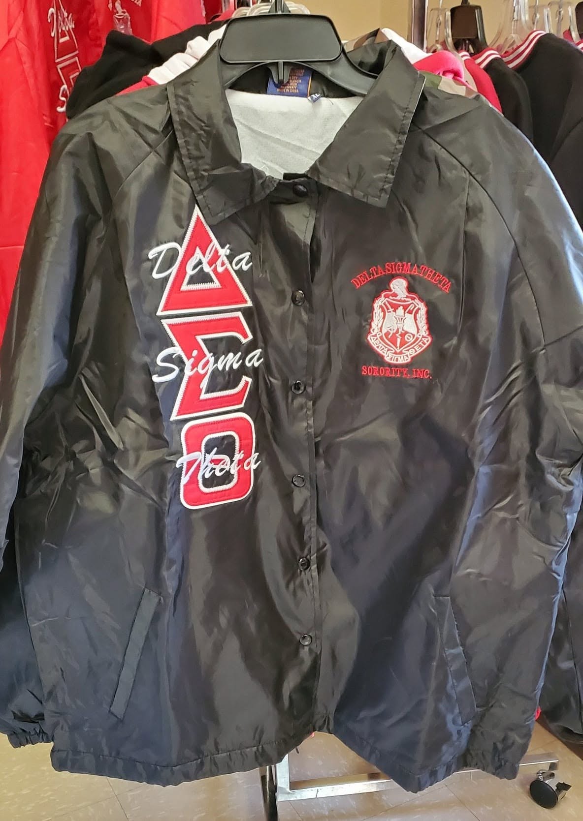 Black DST line jacket with red ΔΣΘ letters and script overlay plus embroidered crest