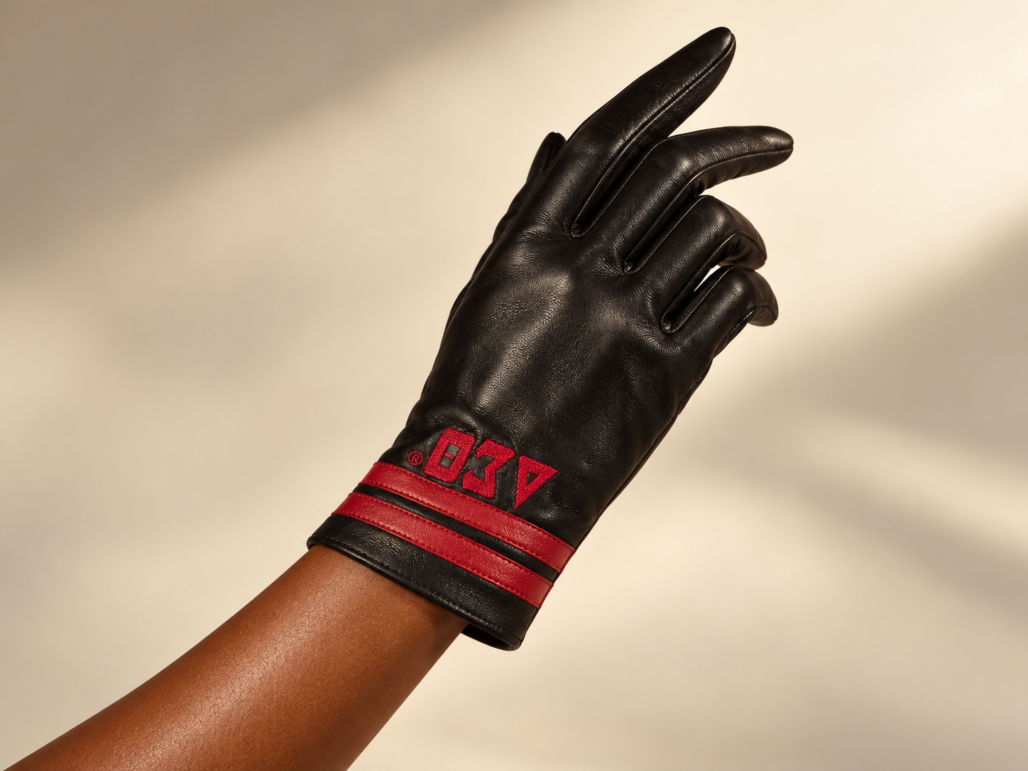 Black leather fashion gloves embroidered with crimson ΔΣΘ letters and red stripe details at the cuff